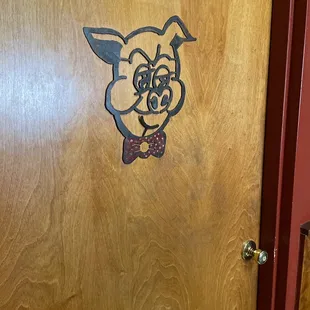 Men's room door has bow tie.