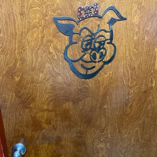 Ladies room door has hair bow.