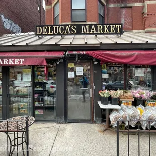 a woman walking past a deluca&apos;s market