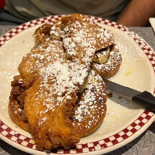 a plate of french toast with powdered sugar on top