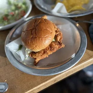 Front: Spicy Chicken Sandwich  Top Left: Chicken B.L.A.T Top right: Chips and Guac