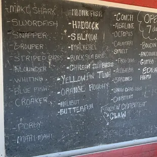 a blackboard with a list of seafoods
