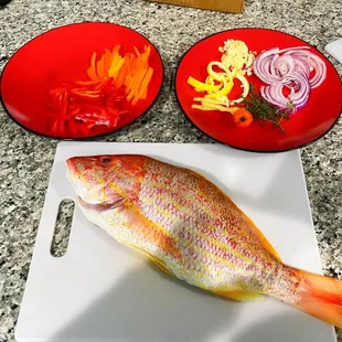 a whole fish on a cutting board