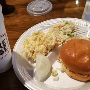 Pulled pork sammich with slaw inside. Side order of slaw and potato salad.