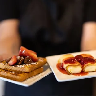 a person holding two plates of food