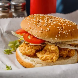 a chicken sandwich with lettuce and tomatoes