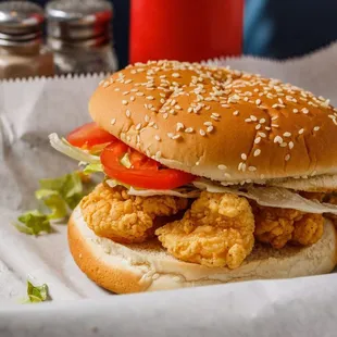 a chicken sandwich with lettuce and tomatoes