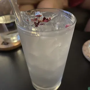 a glass of water with ice and a straw