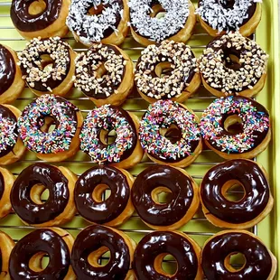Chocolate iced donuts with sprinkles, peanuts and coconuts