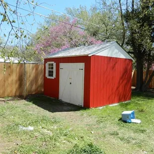 a red shed with a white door