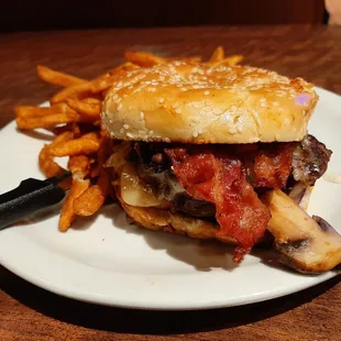 Bourbon Bacon Burger: cheese, bacon, mushrooms, bell peppers &amp; onions, bourbon sauce, lettuce, tomato, onions, pickles with a brioche bun.
