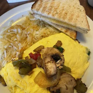 Loaded Veggie Omelette with Hash Browns and white Slices of Toast