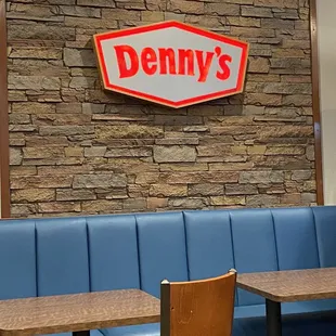 a restaurant with blue booths and a sign that says denny's
