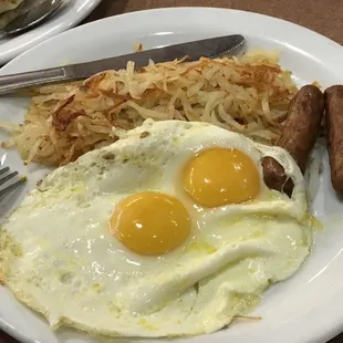 Sunny side up eggs, hash browns, and sausages