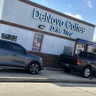 two trucks parked in front of a coffee shop