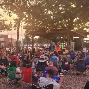 a crowd of people sitting in lawn chairs