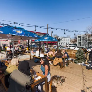 people sitting at tables under umbrellas