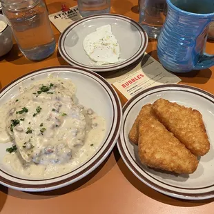 Biscuit with sausage gravy and a side of hashbrowns.