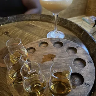 four glasses of whiskey on a barrel