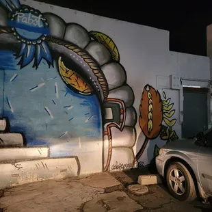 a car parked in front of a mural