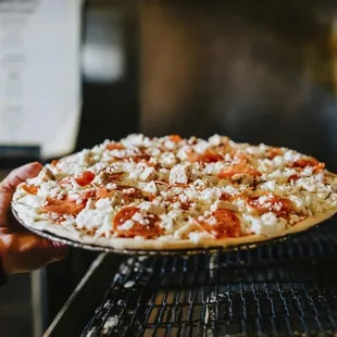 a hand holding a pizza