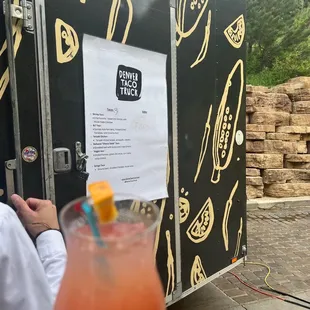 a drink in front of a taco truck