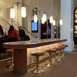 a bar with stools and a television