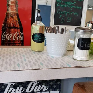 a counter with a sign and a bottle of beer