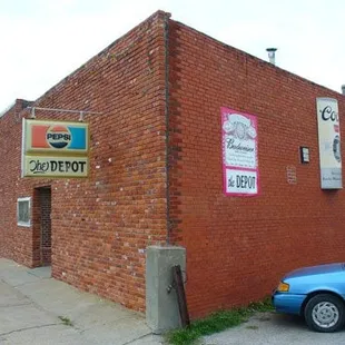 a blue car parked in front of a red brick building