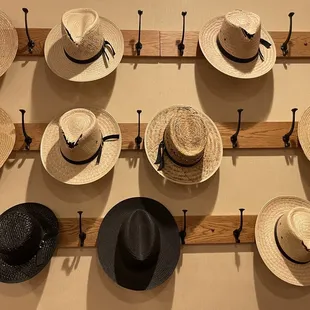 a wall of hats hanging on hooks