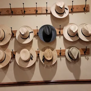 a wall of hats hanging on hooks