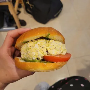a person holding a sandwich in their hand