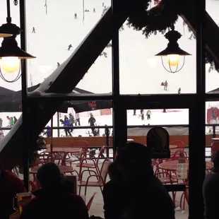 Watch skiers come down while you are warm with a beer.
