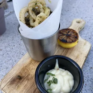 a bowl of onion rings and a bowl of sour cream