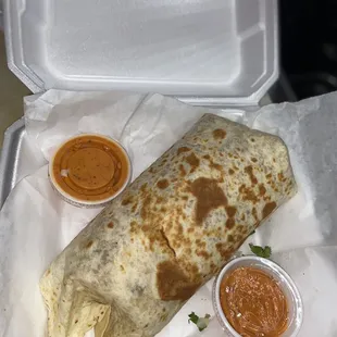 Big burrito with steak, cheese, beans, rice, tomatoes, lettuce, cilantro, onions and red sauce.