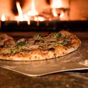 a pizza in front of a fireplace