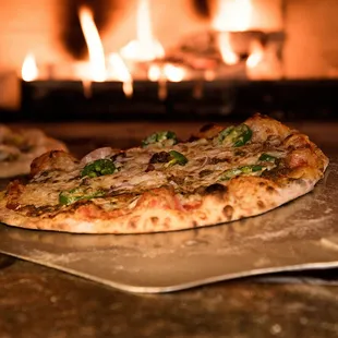 a pizza in front of a fireplace