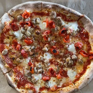 a pizza with pepperoni, sausage and cheese