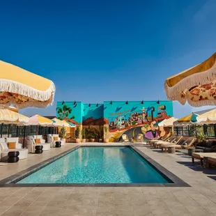 a pool with lounge chairs and umbrellas