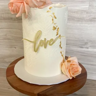 a white wedding cake with pink roses