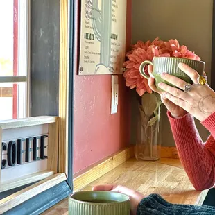 a woman sitting on the floor holding a mug