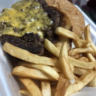 cheeseburger and fries in a styrofoam container