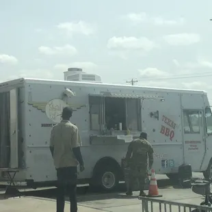 two men standing in front of a food truck