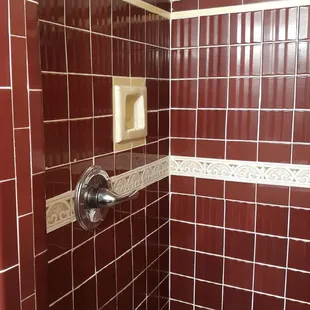 Preserved old rippled-tile in one of the showers with new plumbing fixtures.