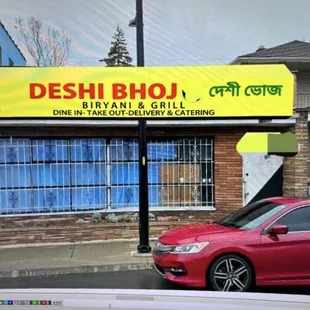 a red car parked in front of a building
