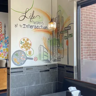 a restaurant with a mural on the wall