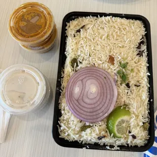 a tray of rice, onion, and pickles