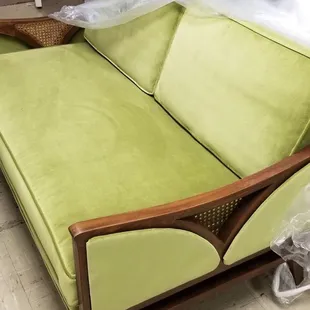 Mid-century love seat in vibrant lime velvet with upholstered side panels