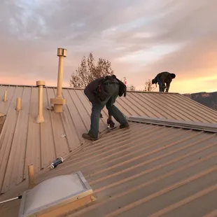 two men working on a metal roof