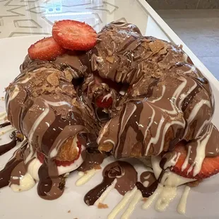 Croissant filled with strawberries and cream and topped with chocolate